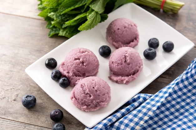 Blueberry ice cream scoops on wooden table