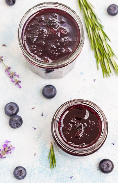 Photo blueberry, lavender and rosemary jam on a bright background