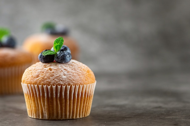 Muffin ai mirtilli su sfondo grigio. vista laterale, copia spazio