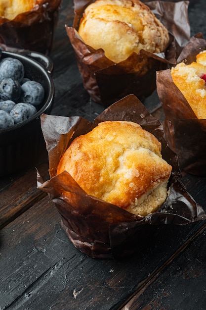 Blueberry muffins with fresh berries, on old dark  wooden table background