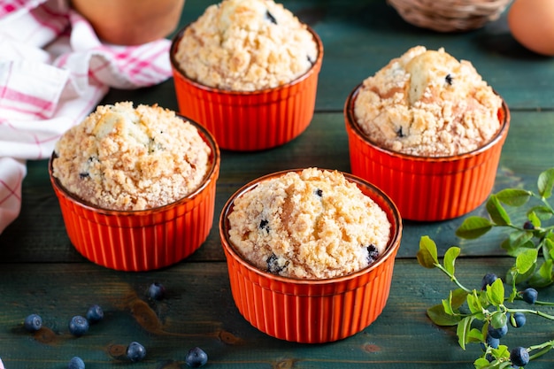 Foto muffin ai mirtilli con zucchero a velo e frutti di bosco freschi sul tavolo verde