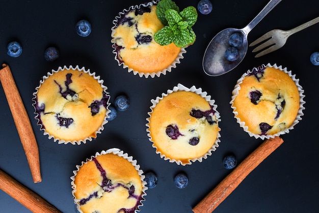 Blueberry muffins with powdered sugar and fresh berries