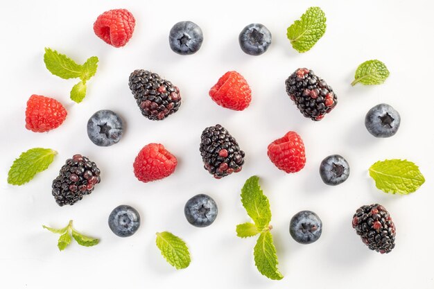 Blueberry mumberry raspberry e foglie di menta su uno sfondo bianco