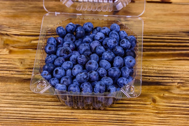 Blueberry in plastic box on a wooden table