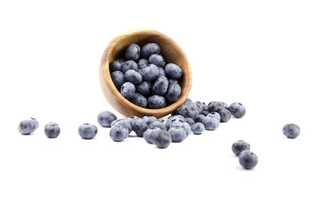 Blueberry in round wooden bowl isolated on white background