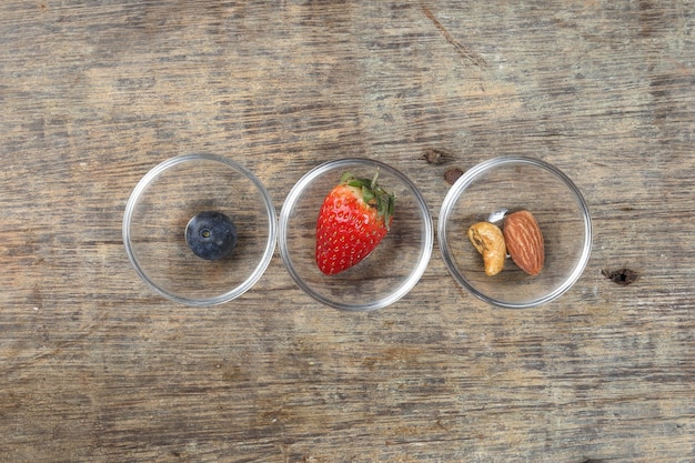 Blueberry Strawberry Herb Spice Almond Cashew Nut in glass bowl on rustic wood background
