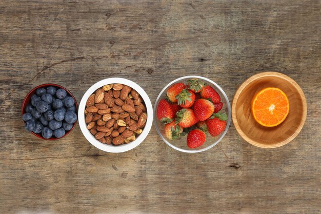 Blueberry Strawberry Herb Spice Almond Cashew Nut Mandarin Orange in bowl on rustic wood background