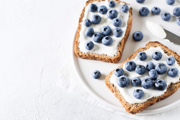 Toast ai mirtilli a colazione su sfondo bianco. cibo salutare