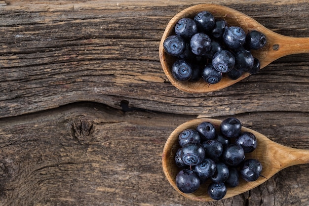 Blueberry with wooden spoon on wooden table.