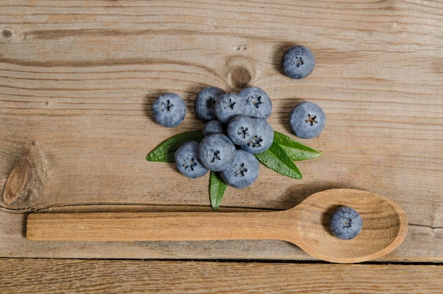 Blueberry in wooden spoon and on wooden table