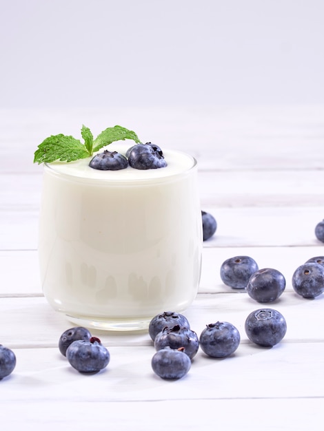 Blueberry yogurt glass on white wooden table