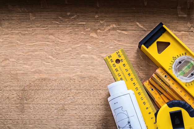 Blueprints and set of instruments of measurement on oak wood board construction concept