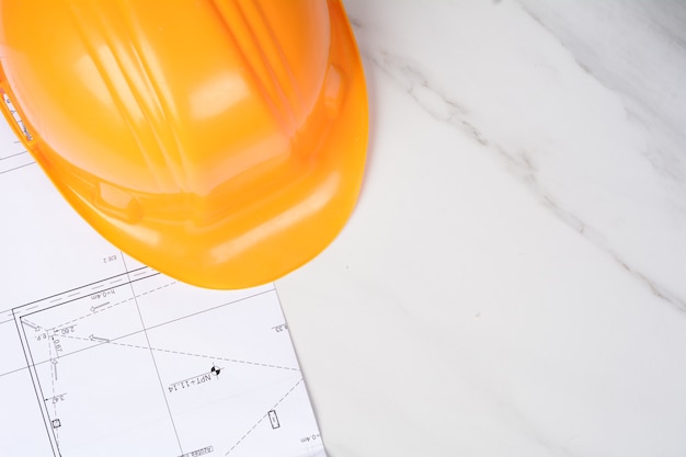 Blueprints and yellow construction helmet.