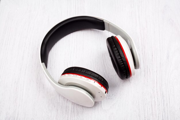 白い木の背景にBluetoothヘッドフォン