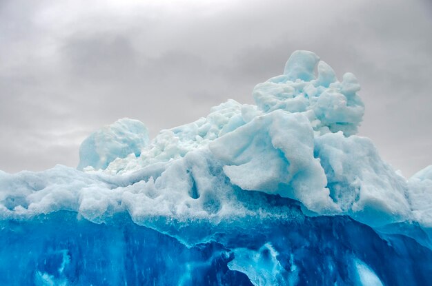 Photo bluish iceberg in a gray sky