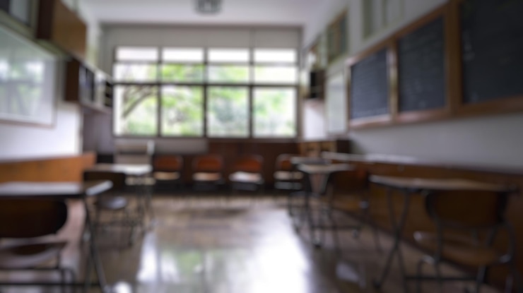 Photo blur background of empty classroom with table chairs and blackboard spate