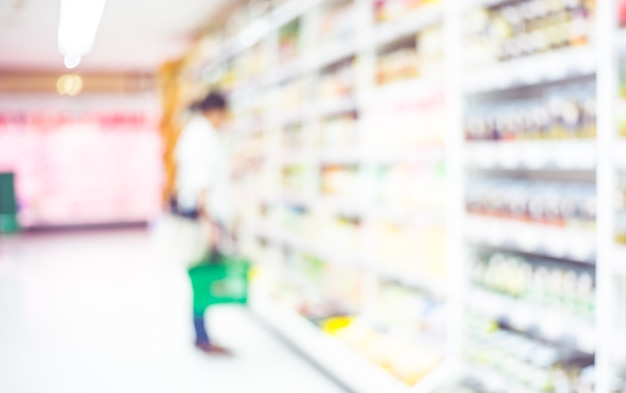 Blur background of woman customer select fresh product on shelf in supermarket