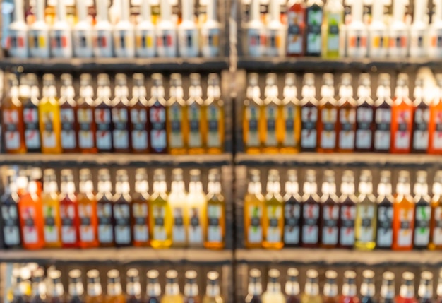 Blur bottles of spirits and liquor on bar counter