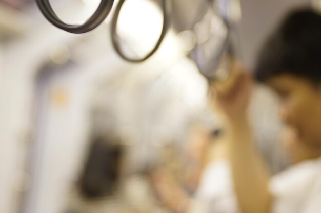 Blur of a boy is holding a strap in a train