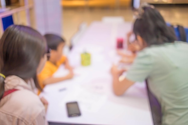 Blur image Little girl drawing at table