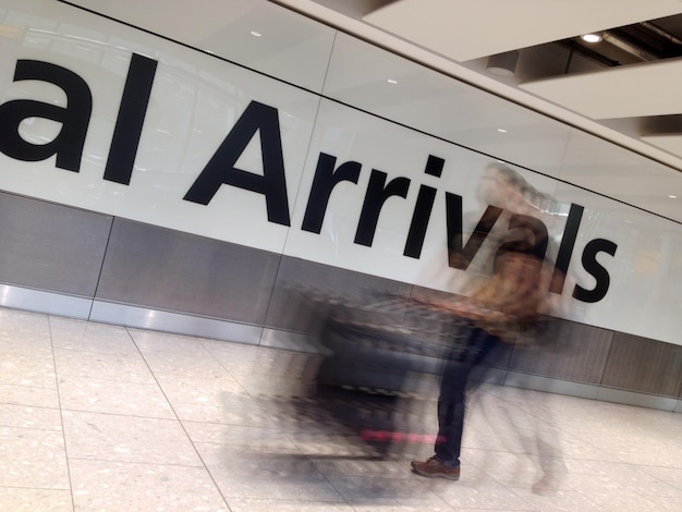 Foto immagine sfocata di un uomo con i bagagli che cammina nell'aeroporto