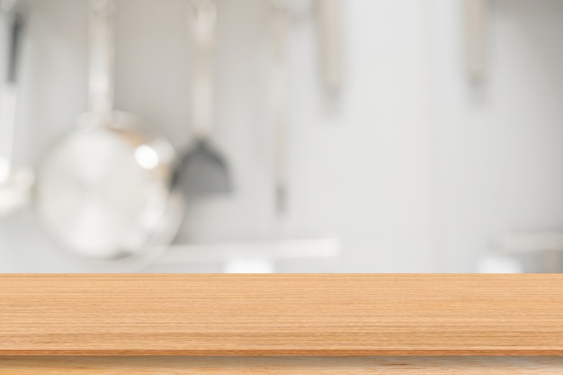 blur inside modern kitchen with cooking equipment and wood table for show,promote product background