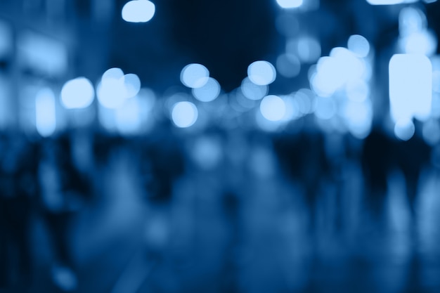 Blur people shopping in local street market with blue bokeh and sun light abstract background.