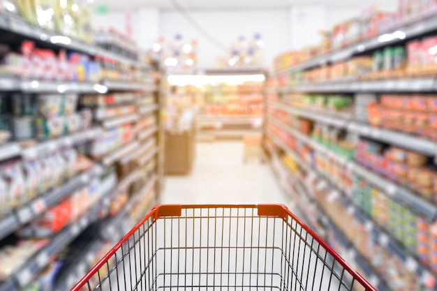 Blur Supermarket aisle with empty red shopping cart