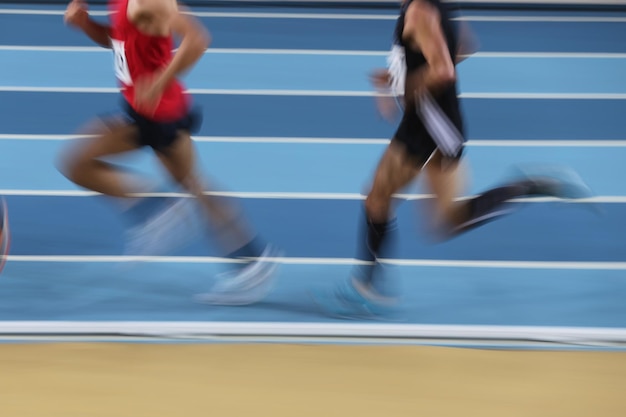 Blured athletes run in track and field