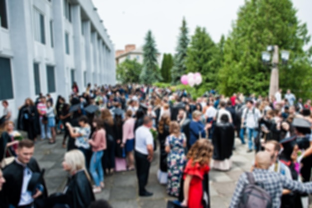 Blured photo of graduates and their parents or friends are waiting for the prom ceremony outside