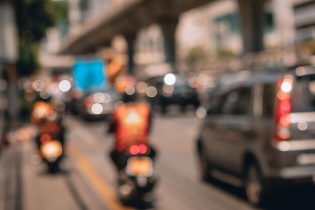 Blured photo of the road along which cars and motorbikes are riding in the center of a big city