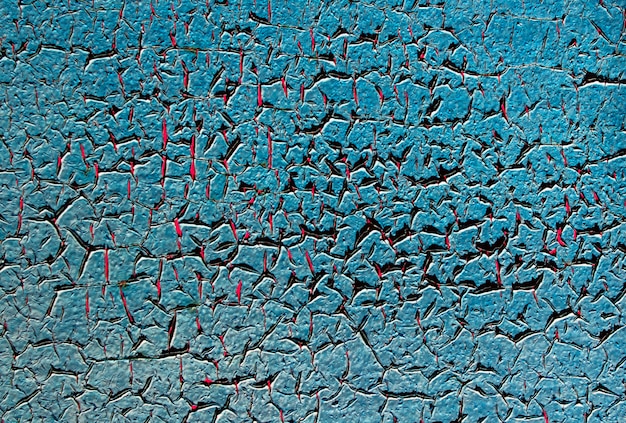 Blured texture of blue peeling paint on a rusty metal surface.