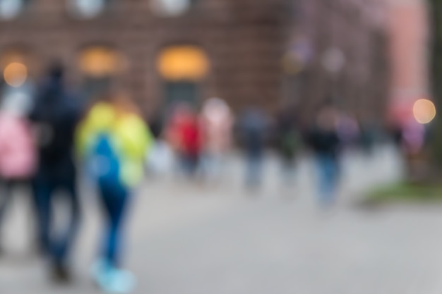 Blurred abstract background. Unrecognizable silhouettes of people walking on city street