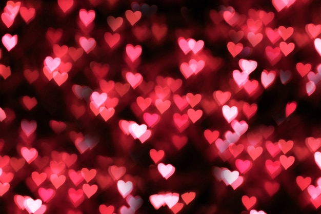 Blurred background, bokeh in the form of a heart of red color.