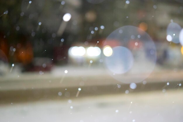 Blurred background Cars driving along road in city during snowfall