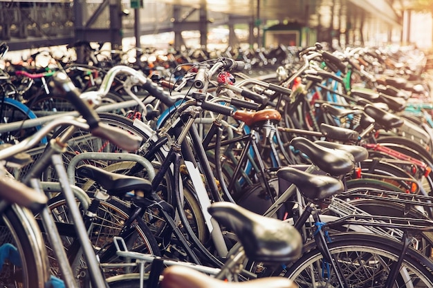 雨の日に駐車場にあるさまざまな自転車のぼかした背景 アムステルダムに駐輪された自転車