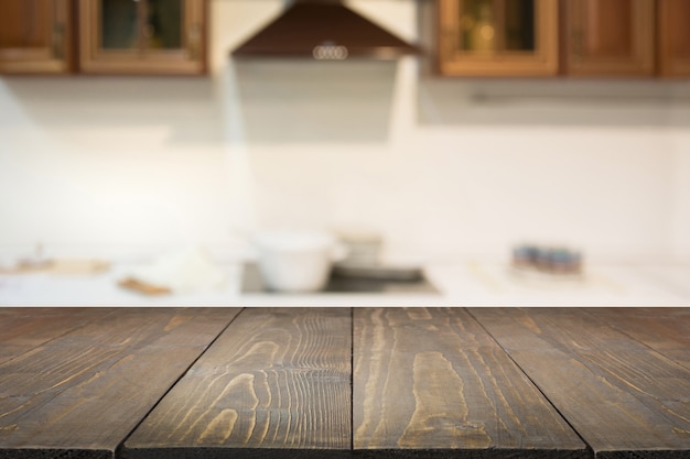 Blurred background empty wooden tabletop and defocused modern kitchen for display or montage your