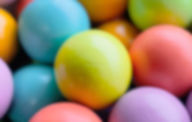 Blurred background from multicolored bright small wooden balls of blue, yellow, red, lilac and green colors. A beautiful summer bright background for your projects.