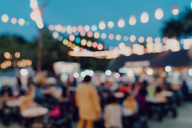 Fondo vago alla gente di festival del mercato di notte che cammina sulla strada.