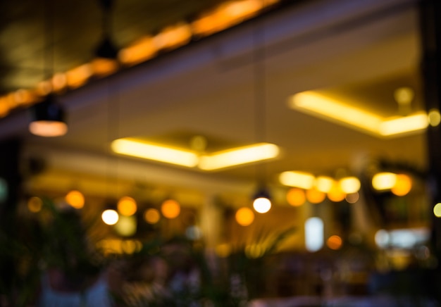 Photo blurred background. restaurant with tables and chairs blur background with bokeh light.