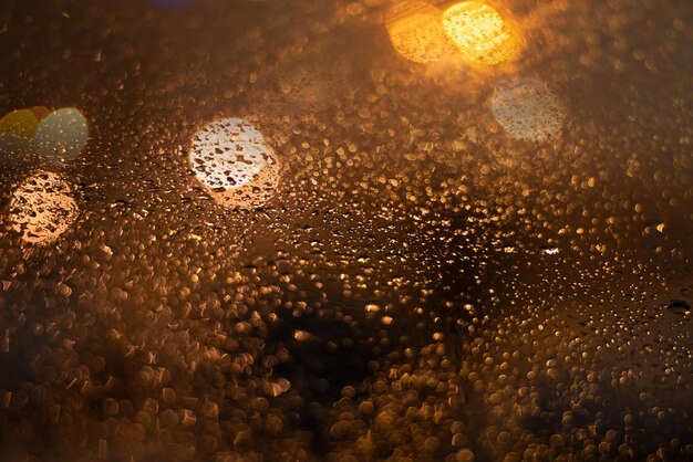 雨滴とライトでぼやけた背景