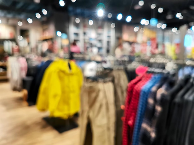 Blurred backgroung of clothing store with discount sign and\
variety of clothes for newborn kids toddlers babies