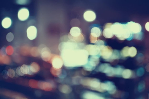 blurred bokeh city background / glare and glowing light in night city, modern beautiful bright background