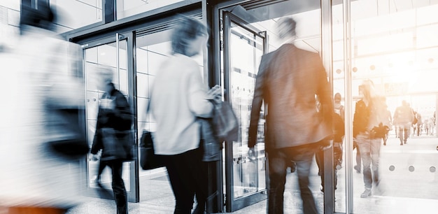 Blurred business people at a trade fair entrance