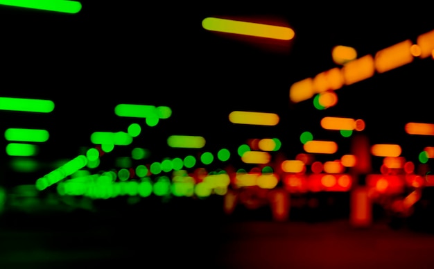Blurred cars in car parking lot in shopping mall. Bokeh lights background. Abstract blur car parking lot for background. Blurred cars parking and bokeh light