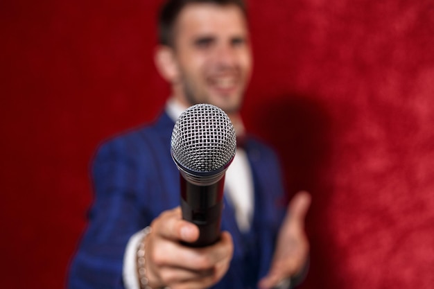 Blurred cheerful showman with microphone entertaining audience