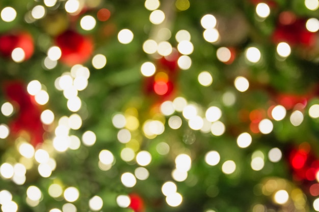 Blurred Christmas tree with golden garland and red balls. Abstract background. Xmas.