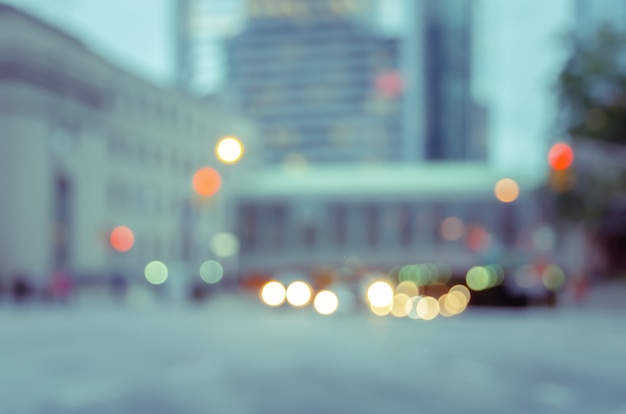 Blurred city street with traffics light bokeh and buildings background
