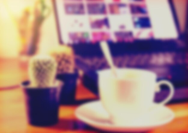 Photo blurred coffee cup and laptop