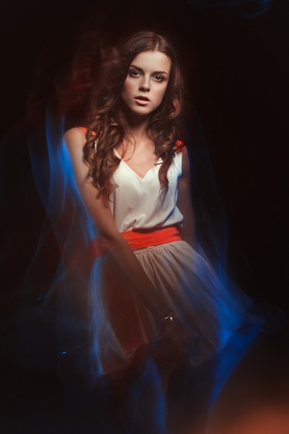 Blurred color portrait of a girl. Fashion woman with beautiful makeup and a light summer dress.